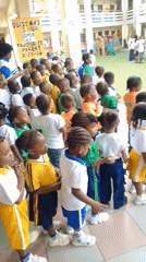School children gather in uniforms at Idimu courtyard