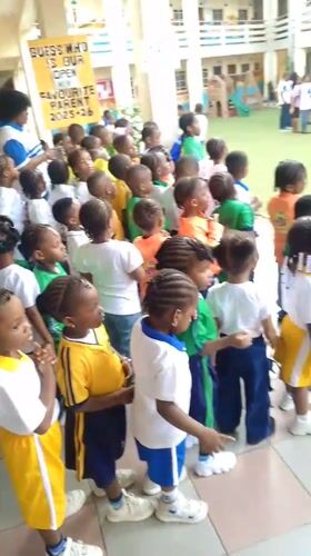 School children gather in uniforms at Idimu courtyard