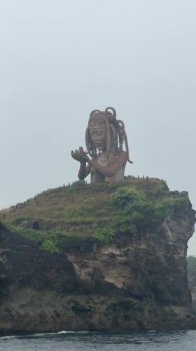 Weathered statue observed on cliff overlooking ocean in Nusa Penida