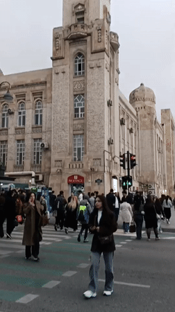 Pedestrians cross street during green light in Baku