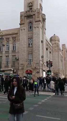 Pedestrians cross street during green light in Baku