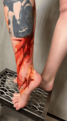Person displays leg tattoos on stool in Moscow