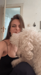 Woman plays with white dog in Krasnoyarsk apartment