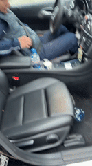 Man in navy jacket sits in black Mercedes driver seat