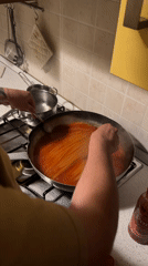 Person cooks spaghetti dinner in Milan kitchen
