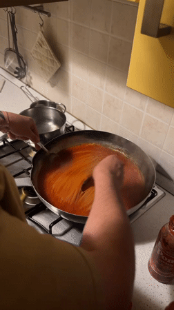 Person cooks spaghetti dinner in Milan kitchen