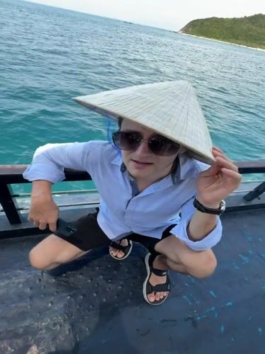 Tourist in conical hat photographed on boat near Nha Trang