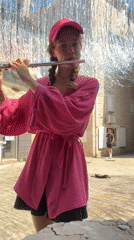 Young woman performs flute music in Budva plaza