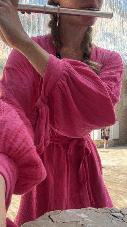Young woman performs flute music in Budva plaza