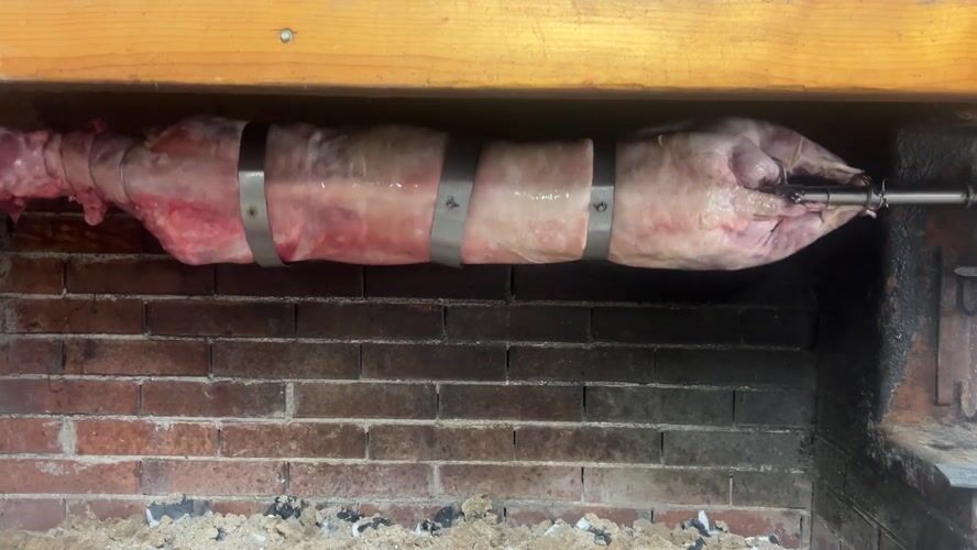 Lamb roasts on rotisserie in Bulgarian village fireplace