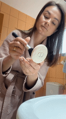 Woman applies makeup in Montenegro bathroom