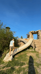Cows graze near pond while visitor explores structures in Lukovit