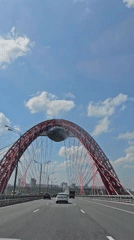 Vehicle crosses distinctive red arch bridge in Moscow