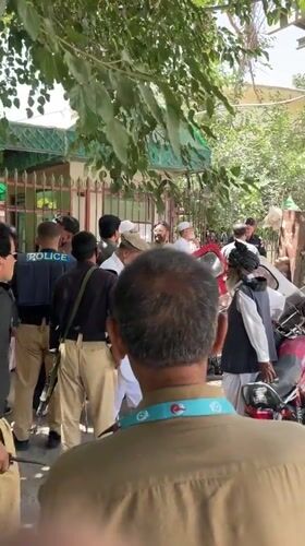 Police gather outside fenced building in Quetta, Pakistan