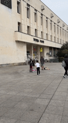 Person photographs pink umbrella installation near Plovdiv post office