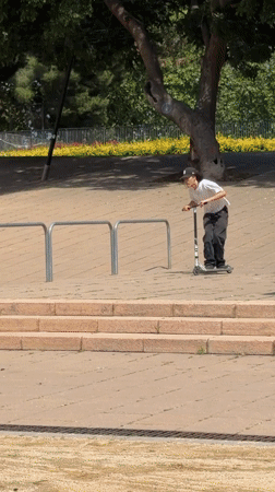 Scooter riders perform tricks at Barcelona urban park