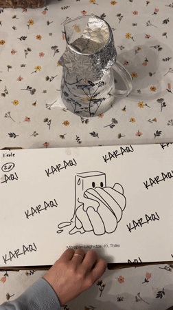 Customer opens KARAQI pastry box in Tbilisi