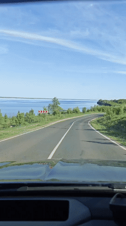 Car travels winding road near water in Khvalynsk, Russia