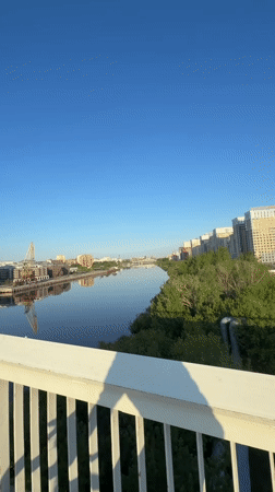Cyclist crosses bridge in Tyumen during early morning hours