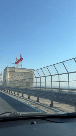Car crosses bridge in Novocheboksarsk under clear skies