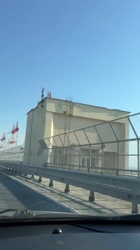 Car crosses bridge in Novocheboksarsk under clear skies