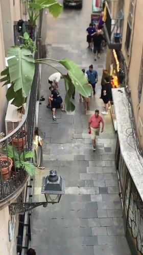 Altercation in a Barcelona cobblestone alley, white truck nearby