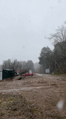 Snow falls on muddy road in rural Chaikovsky, Russia