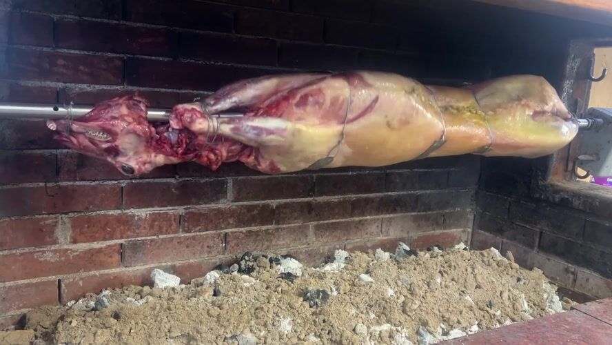Whole lamb roasted on rotisserie in Bulgarian village oven