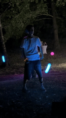 Glow stick juggling and string lights at a nighttime outdoor gathering
