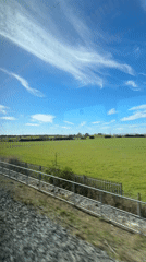 Train passenger films countryside view near Islip