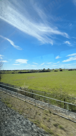 Train passenger films countryside view near Islip