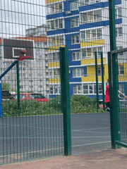 Kids at a city playground, street life nearby