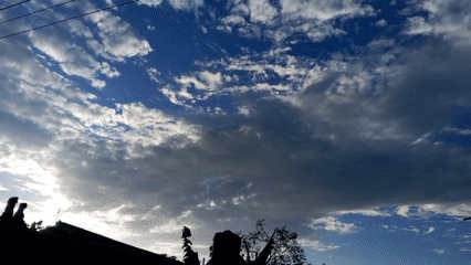 Witness captures partly cloudy sky with silhouetted landscape below