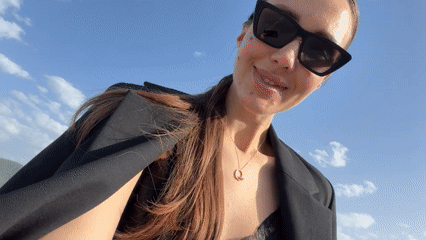Woman in black blazer observed outdoors in sunny Milas