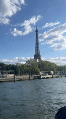 Tourist captures Eiffel Tower views during Seine River boat tour