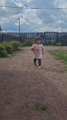 Child plays with dog in Russian village garden