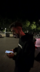 Man checks phone while smoking on Bragança street
