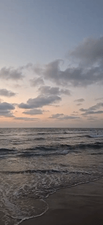 Dusk settles over a quiet beach and parking lot