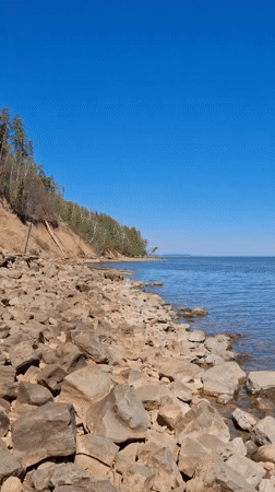 Person in protective gear explores rocky coastline in Noviy