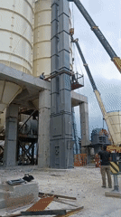 Crane lifts modular tower between silos at Armenian industrial site