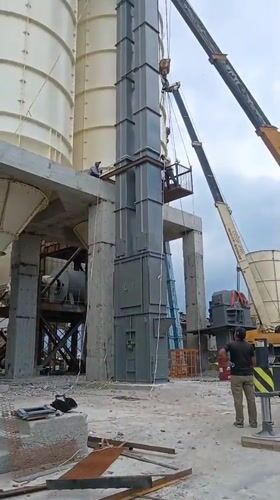 Crane lifts modular tower between silos at Armenian industrial site