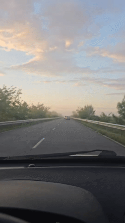 Car travels rural road in Sarnevo, Bulgaria early morning