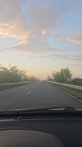 Car travels rural road in Sarnevo, Bulgaria early morning