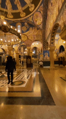 People in dark clothing walk through Orthodox church in Bar