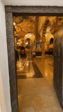 People in dark clothing walk through Orthodox church in Bar
