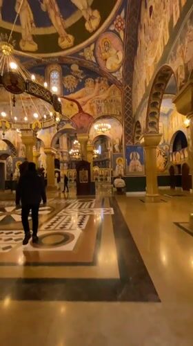 People in dark clothing walk through Orthodox church in Bar