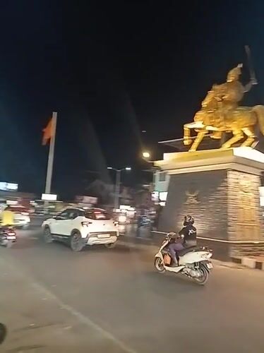 Golden horseman statue anchors busy Oxel traffic circle at night