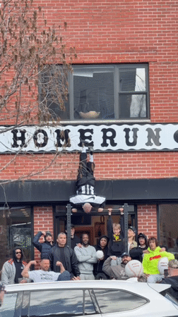 Man performs handstand on pull-up bar outside NYC building