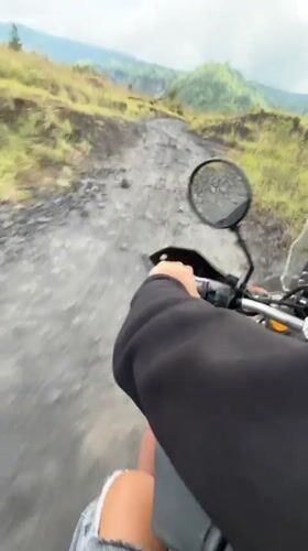 Motorcyclist rides dirt road in rural Kintamani, Indonesia