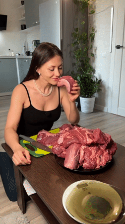Woman prepares raw meat in Murino kitchen